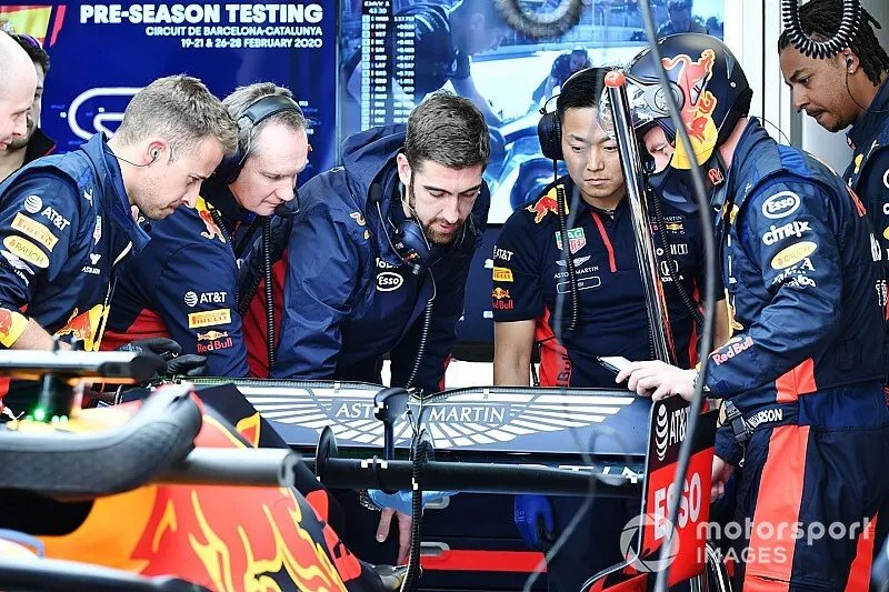 Red Bull team members examine the rear of a Red Bull Racing RB16