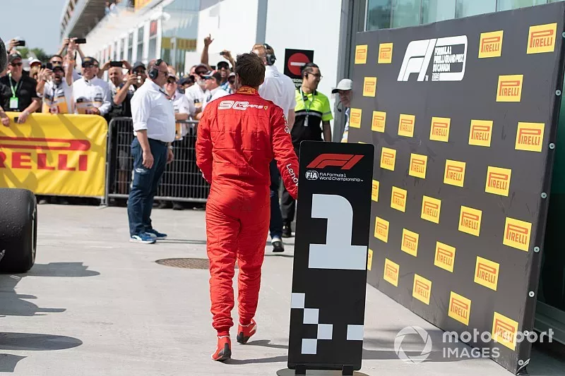 Sebastian Vettel, Ferrari, 2&deg; classificato, si dirige verso il podio dopo aver scambiato le posizioni delle insegne davanti alle monoposto