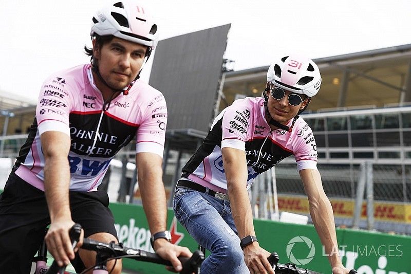 Esteban Ocon, Force India y Sergio P&eacute;rez, Force India, andan por el circuito en bicicleta