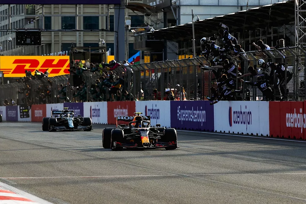 Sergio Perez, Red Bull Racing RB16B, 1st position, takes the chequered flag to the delight of his team on the pit wall
