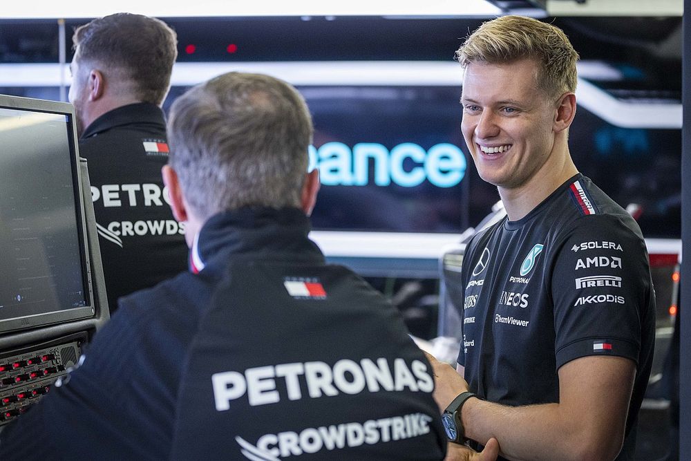 Mick Schumacher, Mercedes-AMG reserve driver, talks to colleagues in the team's garage
