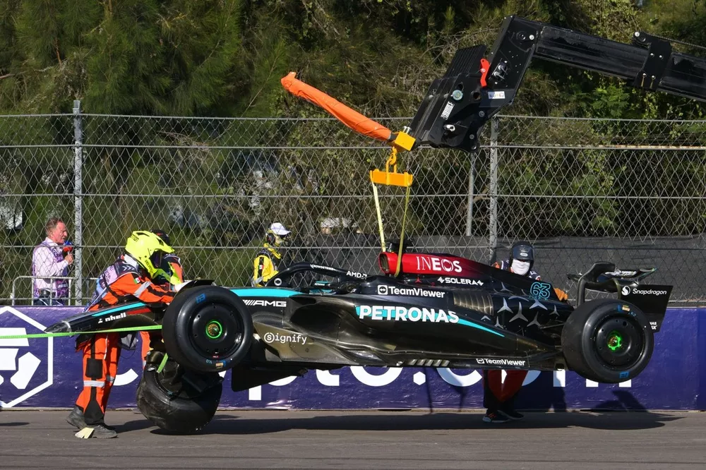 Comisarios recogiendo piezas del coche de George Russell, Mercedes F1 W15 