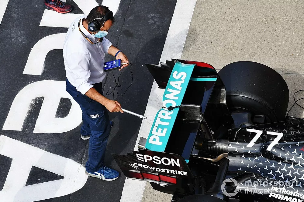 An FIA delegate inspects the car of Valtteri Bottas, Mercedes F1 W11, in Parc Ferme