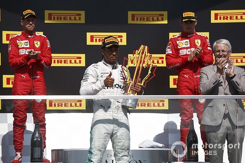 Sebastian Vettel, Ferrari, 2nd position, Lewis Hamilton, Mercedes AMG F1, 1st position, with his trophy, and Charles Leclerc, Ferrari, 3rd position, on the podium