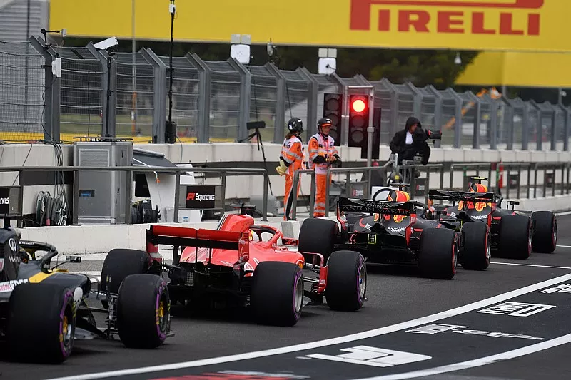 Los coches hacen cola en la luz roja en el carril de boxes