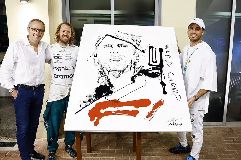 Artist Mr Dripping and Stefano Domenicali, CEO, Formula 1, present a painting to Sebastian Vettel, Aston Martin