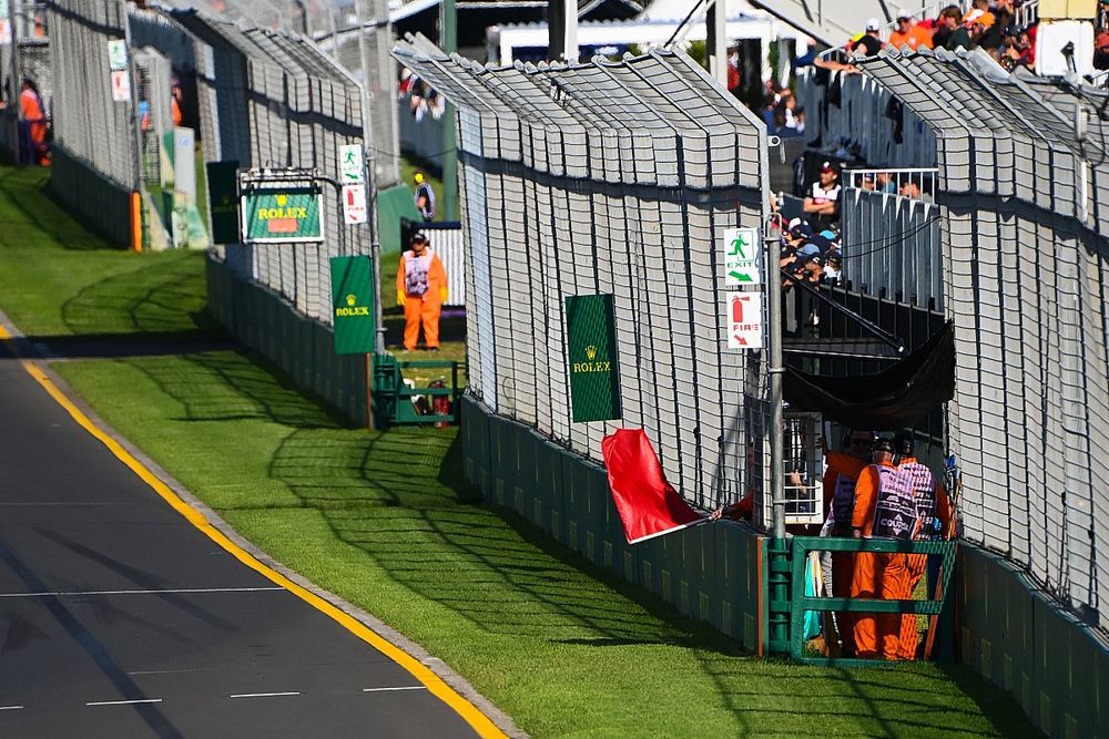 A marshal waves a red flag