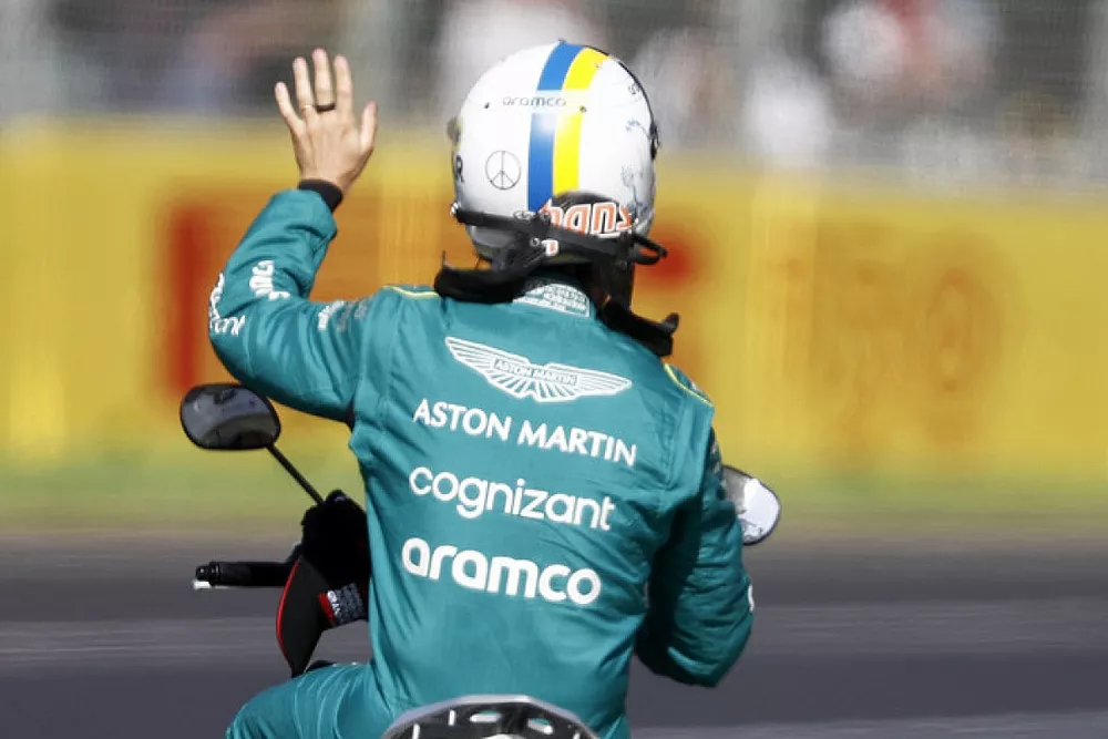 Sebastian Vettel, Aston Martin, gets a ride back to the pits