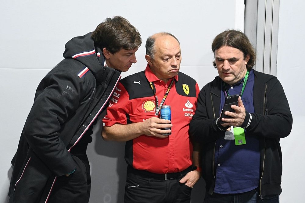 Toto Wolff, director de equipo y consejero delegado de Mercedes-AMG, y Frederic Vasseur, director de equipo y director general de la Scuderia Ferrari, miran un teléfono antes de la rueda de prensa de los representantes de los equipos.