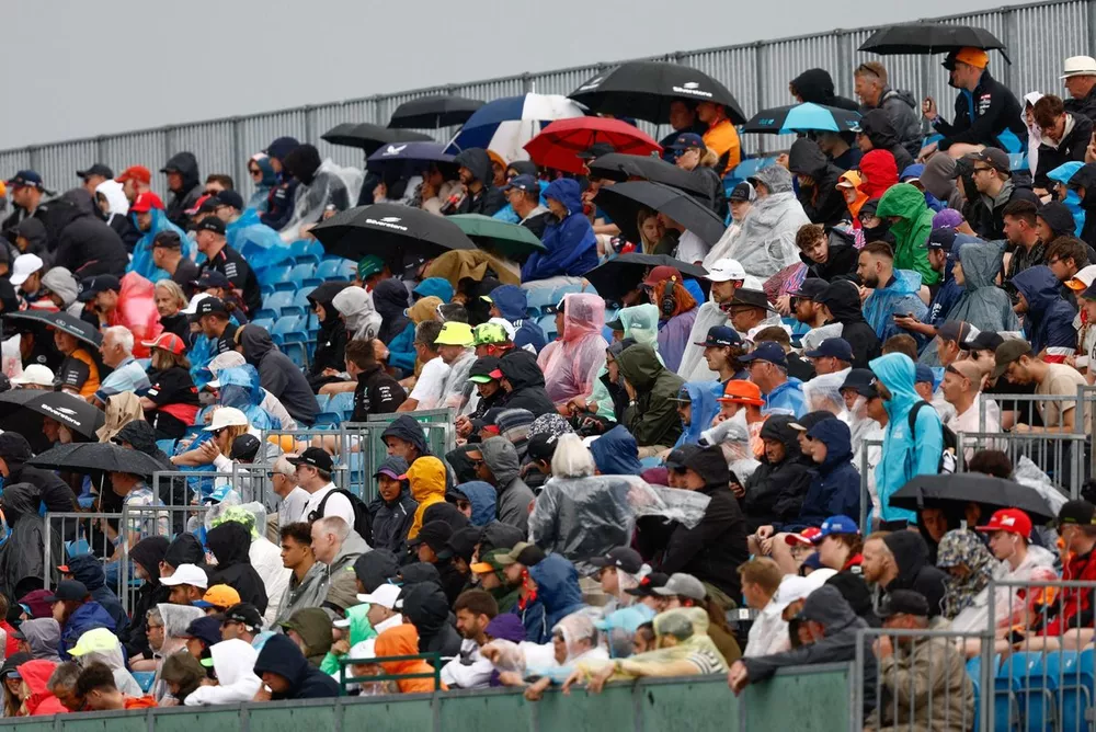 Fans defend against the rain in a grandstand