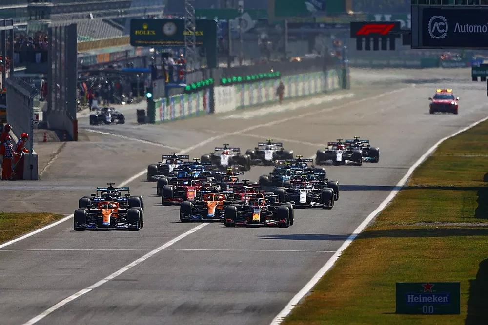 Daniel Ricciardo, McLaren MCL35M, Max Verstappen, Red Bull Racing RB16B, Lando Norris, McLaren MCL35M, Lewis Hamilton, Mercedes W12, Charles Leclerc, Ferrari SF21, and the rest of the field at the start