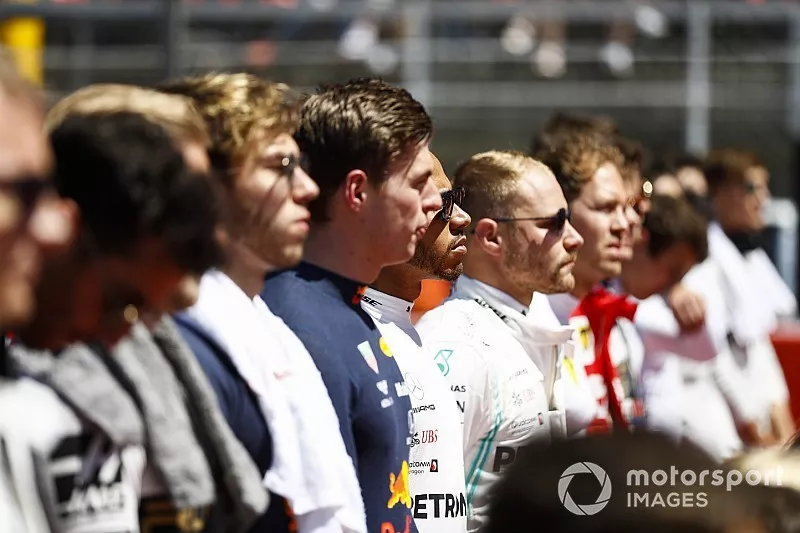 Los pilotos se alinean con los ni&ntilde;os de la cuadr&iacute;cula para el himno nacional antes de la salida.