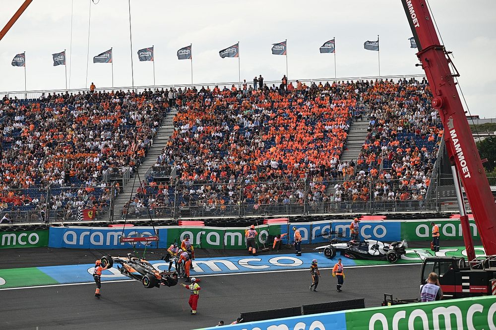 Los oficiales de pista retiran los coches dañados de Oscar Piastri, McLaren MCL60, y Daniel Ricciardo, AlphaTauri AT04.