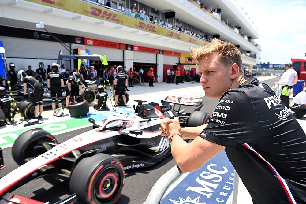 Mick Schumacher, Reserve Driver, Mercedes-AMG, watches as Kevin Magnussen, Haas VF-23, passes in the pit lane