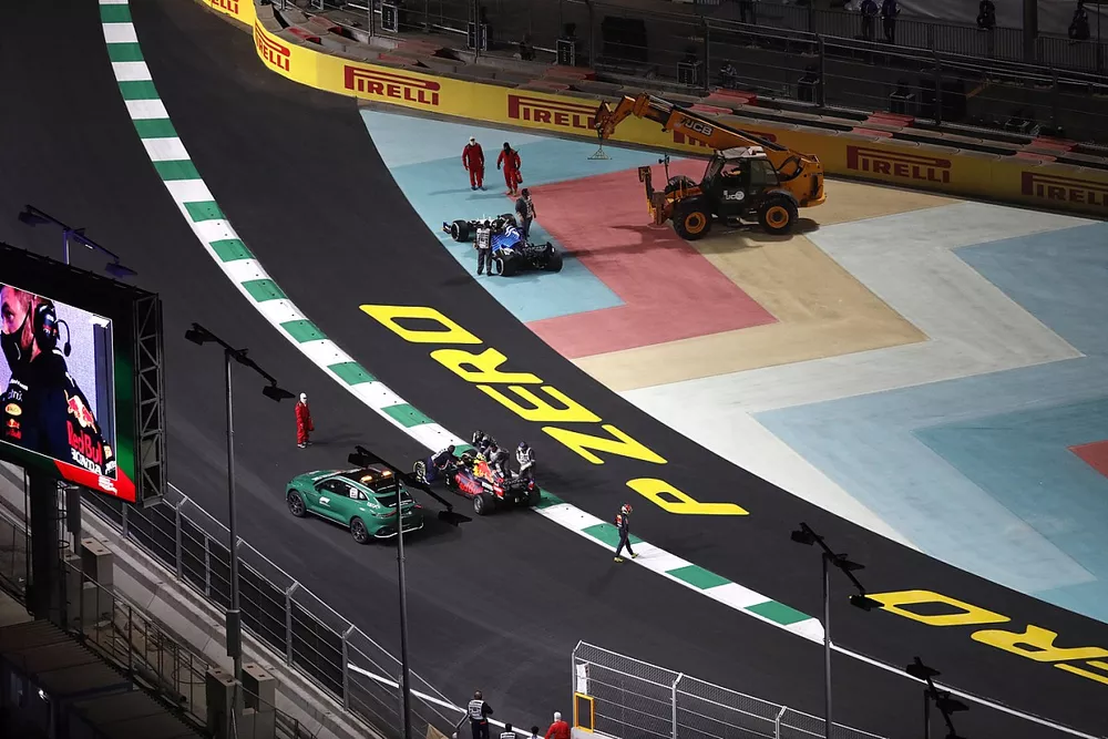 Marshals attend the crash of Sergio Perez, Red Bull Racing RB16B, and George Russell, Williams FW43B