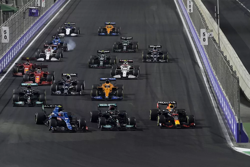 Max Verstappen, Red Bull Racing RB16B, Lewis Hamilton, Mercedes W12, and Esteban Ocon, Alpine A521, battle for the lead at the restart