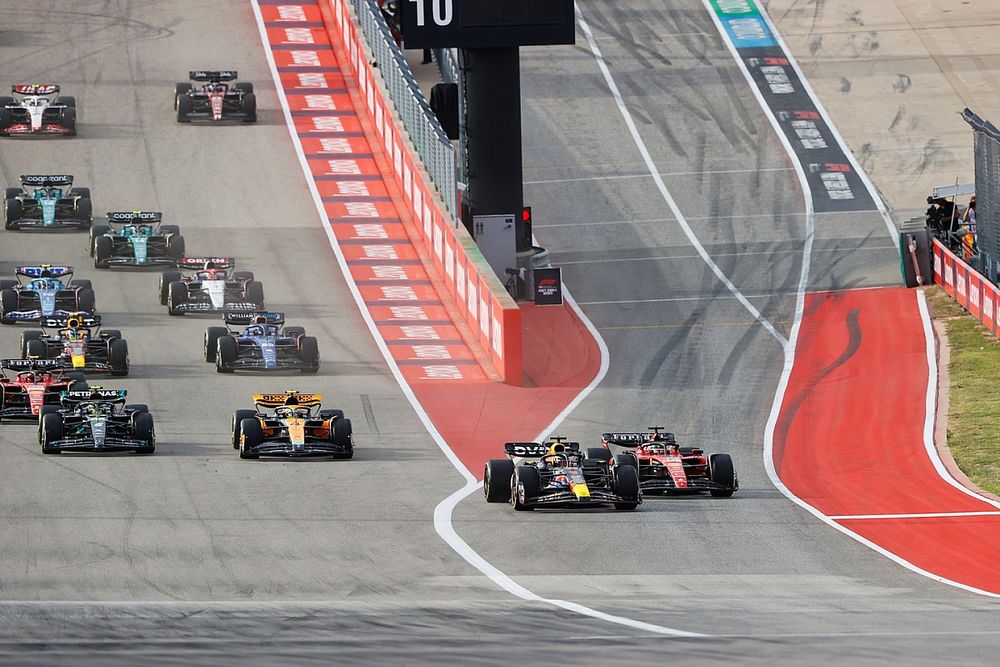 Max Verstappen, Red Bull Racing RB19, squeezes Charles Leclerc, Ferrari SF-23, as they lead Lewis Hamilton, Mercedes F1 W14, Lando Norris, McLaren MCL60, the rest of the field away for the start of the Sprint race