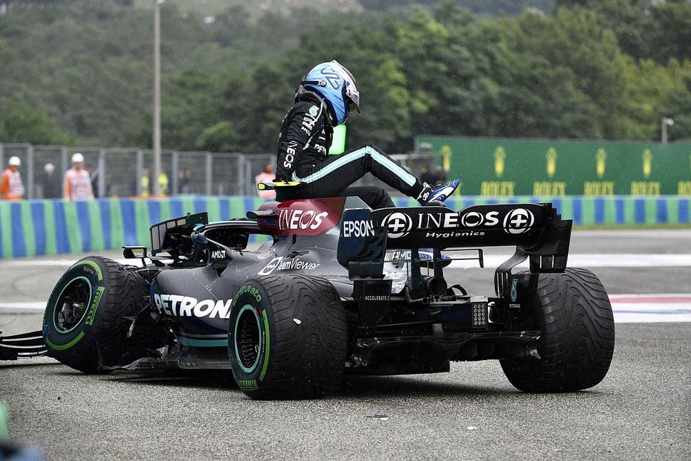 Valtteri Bottas, Mercedes W12, climbs out of his damaged car after crashing out at the start