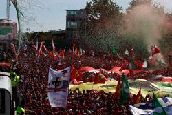 Confeti cae alrededor de la multitud de fans de Ferrari que se reunieron para la ceremonia de podio