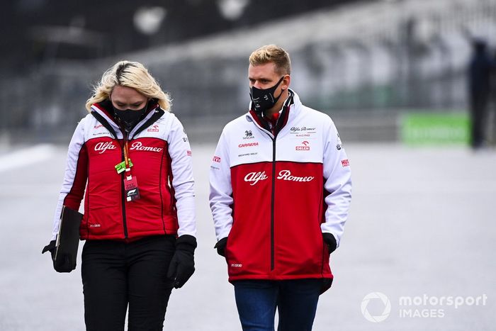 Mick Schumacher, Alfa Romeo, recorre la pista con miembros del equipo