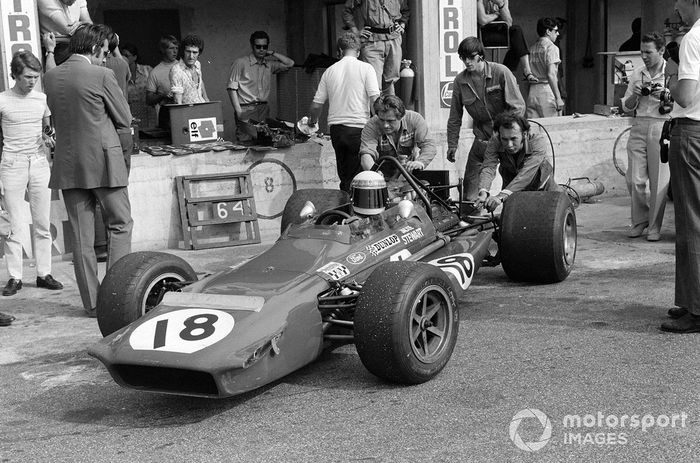 Los mecánicos empujan a Jackie Stewart, March 701 Ford fuera de la caja de boxes