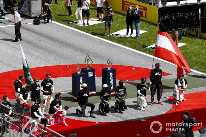 Los pilotos se arrodillan en la parrilla antes de la salida.