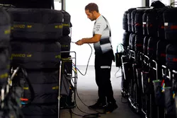 Un mécanicien McLaren avec les pneus Pirelli