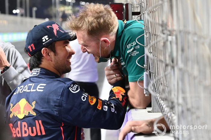 Un miembro del equipo Aston Martin felicita a Sergio Pérez, de Red Bull Racing, por conseguir la pole