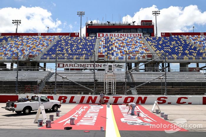 Los trabajadores de la pista pintan logotipos en la parte delantera