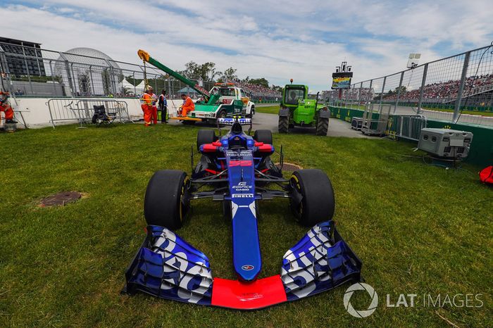 El coche de Carlos Sainz Jr., Scuderia Toro Rosso STR12 es quitado por los oficiales de pista