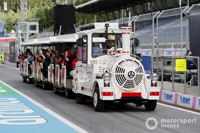 Los aficionados viajan en un tren terrestre por el pitlane