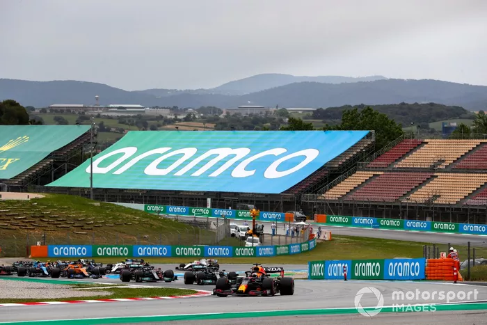 Max Verstappen, Red Bull Racing RB16B, Lewis Hamilton, Mercedes W12, Valtteri Bottas, Mercedes W12, Daniel Ricciardo, McLaren MCL35M, y el resto del pelotón en la primera vuelta