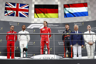 Winner Sebastian Vettel, Ferrari, celebrates on the podium, between Lewis Hamilton, Mercedes AMG F1, and Max Verstappen, Red Bull Racing