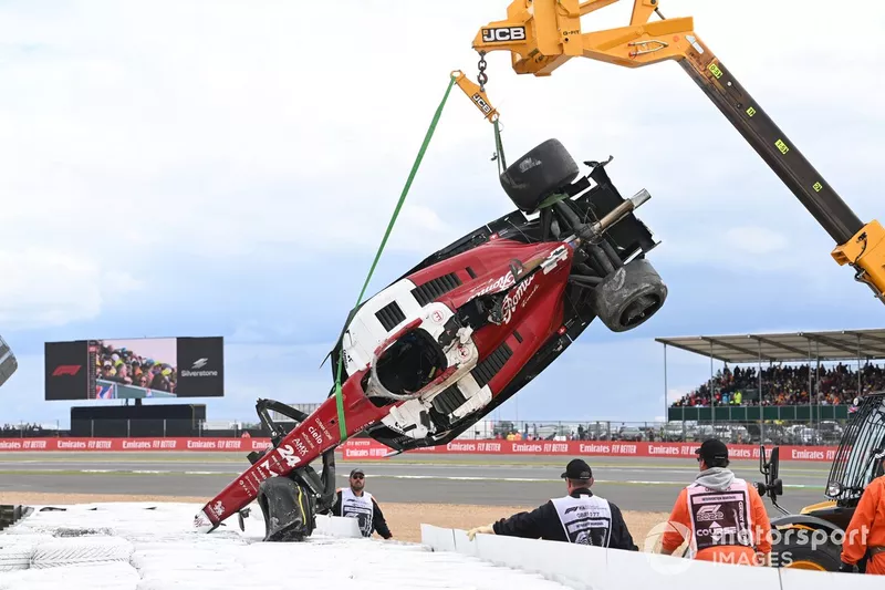 Los oficiales de pista retiran el coche dañado de Zhou Guanyu, Alfa Romeo C42