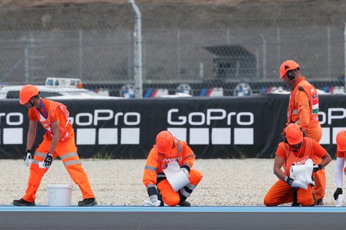 The marshals clean oil off the track.