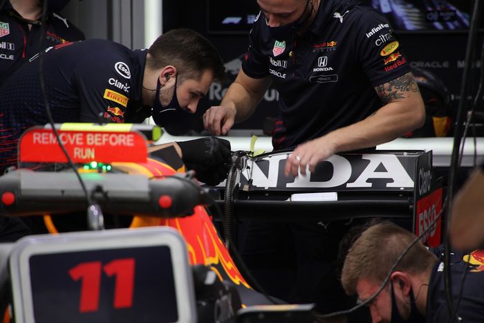 Miembros del equipo Red Bull Racing trabajando en el alerón trasero