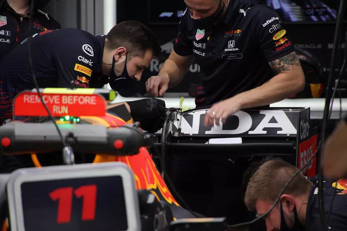 Miembros del equipo Red Bull Racing trabajando en el alerón trasero