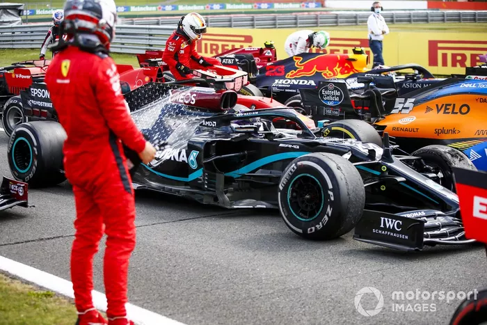 Charles Leclerc, Ferrari in Parc Ferme mira el neumático dañado del monoplaza de Lewis Hamilton, Mercedes F1 W11 
