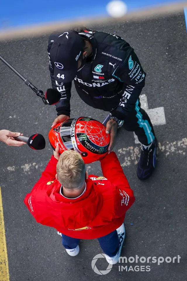 Mick Schumacher, Alfa Romeo Racing, entrega al ganador de la carrera Lewis Hamilton, Mercedes-AMG F1, el casco Mercedes de su padre, Michael Schumacher de 2012