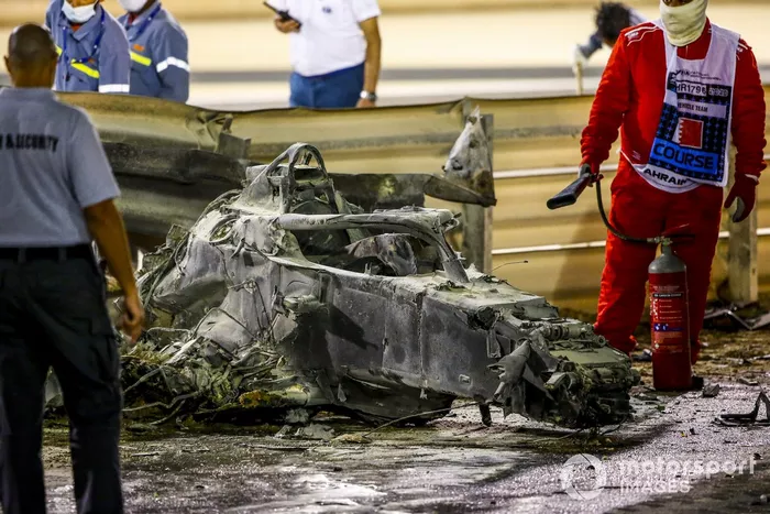 Los restos quemados del monoplaza de Romain Grosjean, Haas VF-20 y la barrera dañada