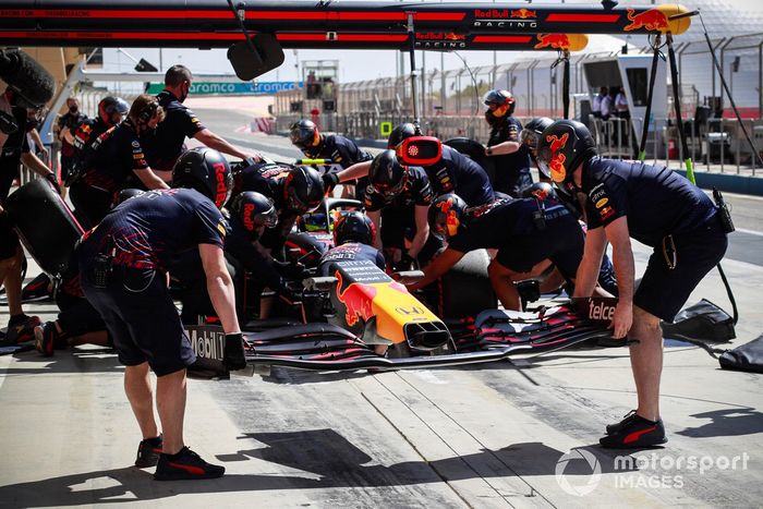 Los mecánicos montan un nuevo alerón delantero en el coche de Sergio Perez, Red Bull Racing RB16B 