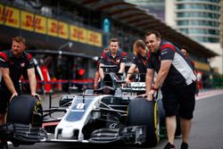 Los miembros del equipo Haas F1 Team empujan el coche de Romain Grosjean Haas F1 Team VF-17 por el p
