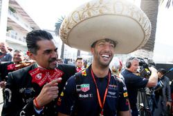 Daniel Ricciardo, Red Bull Racing, dons a sombrero, next to locals in traditional costume