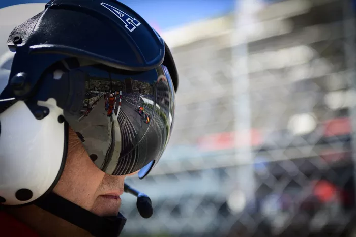 Sergio Pérez, Red Bull Racing RB16B reflejado en el visor de un bombero