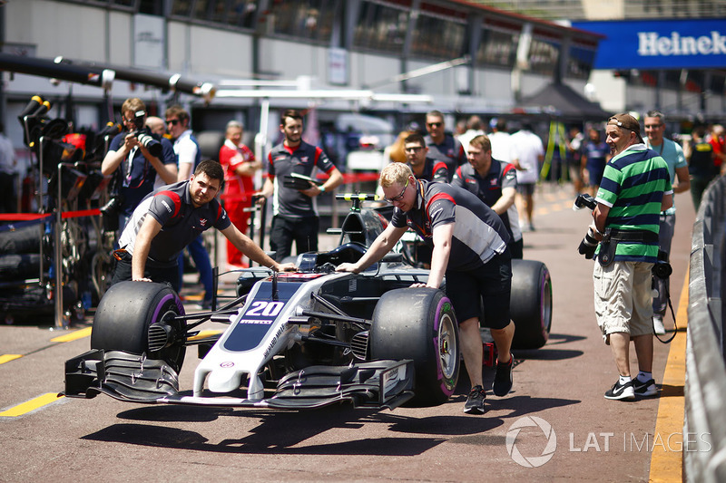 Mecánicos empujan el coche con nueva decoración de Kevin Magnussen, Haas F1 Team VF-17, en el pitlane