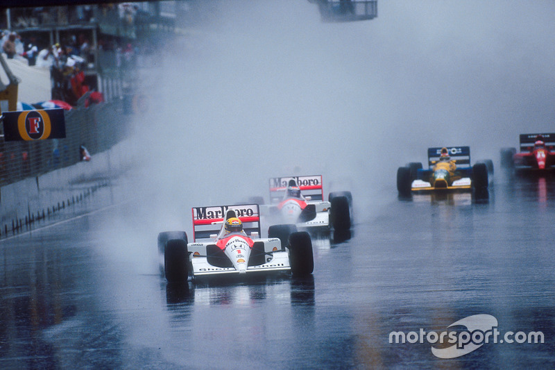 Ayrton Senna leads teammate Gerhard Berger, both McLaren MP4/6 Honda's, Nigel Mansell, Williams FW14 Renault, behind Berger's car in spray, Nelson Piquet, Benetton B191 Ford, and Jean Alesi, Ferrari 643, at the start