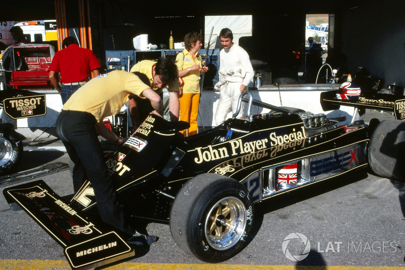 Nigel Mansell, parla con la moglie Roseanne Mansell, mentre i meccanici lavorano sulla sua Lotus 87 nell'area box