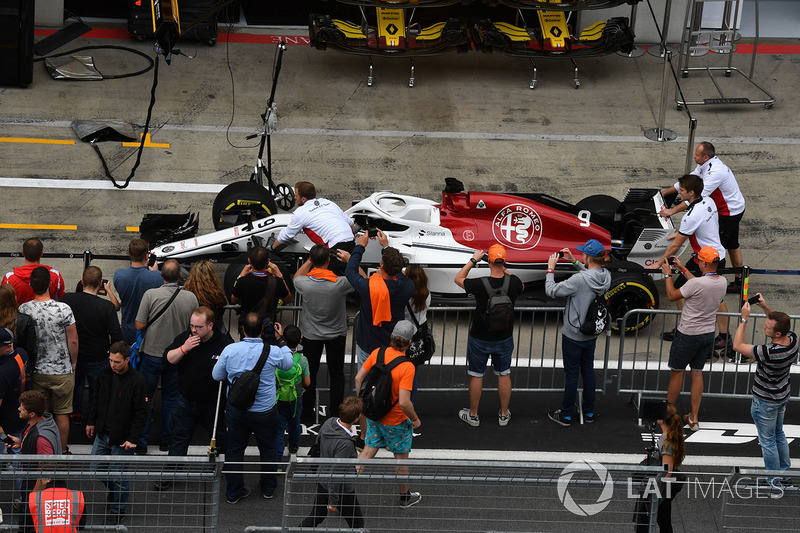 La Sauber C37 dans la pit lane avec des fans