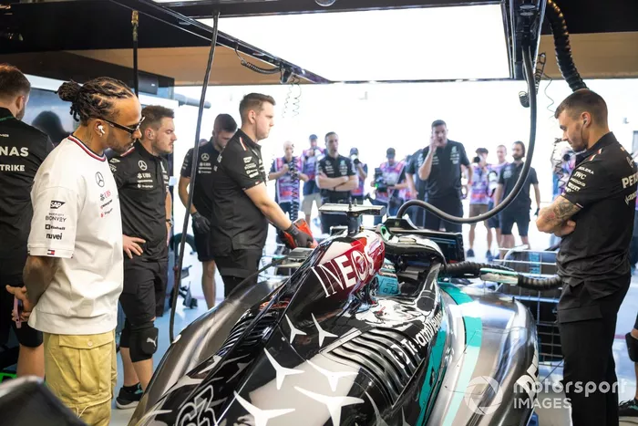 Lewis Hamilton, Mercedes-AMG, guarda l'auto di George Russell, Mercedes F1 W15, in garage 