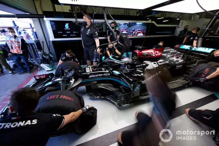 Los mecánicos retiran los calentadores de neumáticos de Lewis Hamilton, Mercedes W12, en el garaje